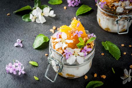 yoghurt met granola, appelsien, munt en eetbare bloemen